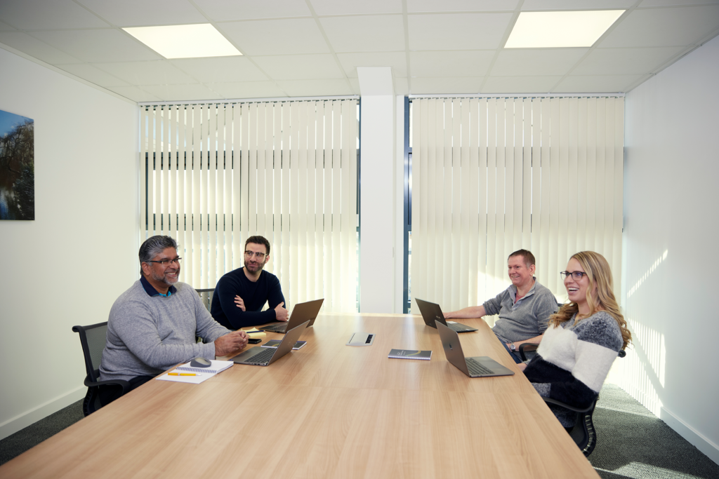 4 people sitting around a board style table