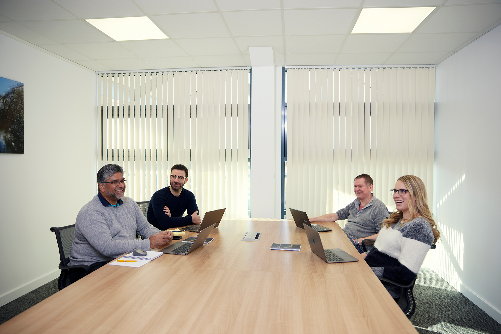 4 people sitting around a board style table